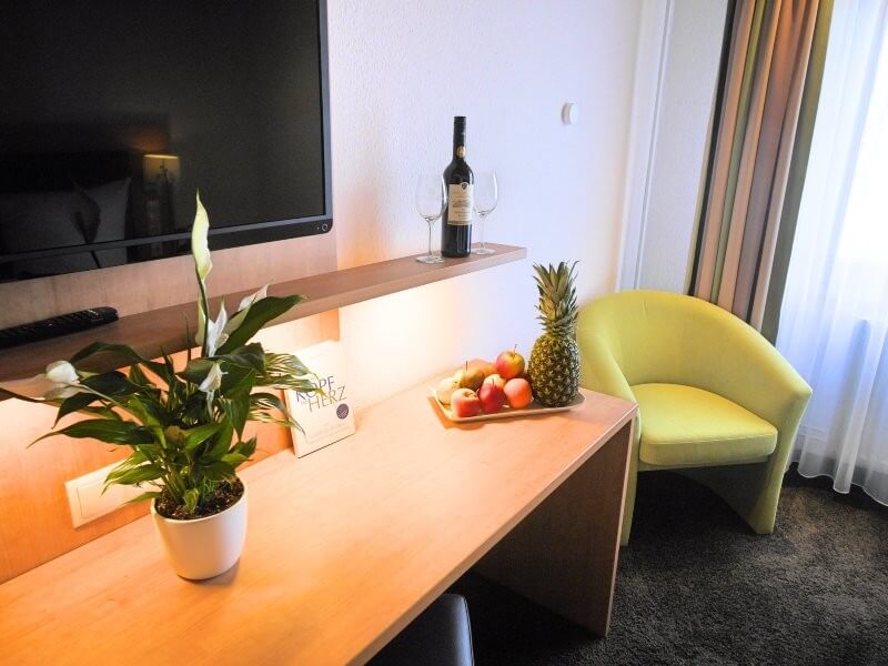Komfortzimmer Blick in ein Hotelzimmer mit Sessel und Tisch