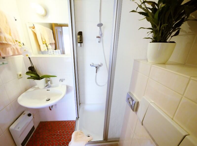 Blick ins Badezimmer mit Dusche, Waschbecken und WC