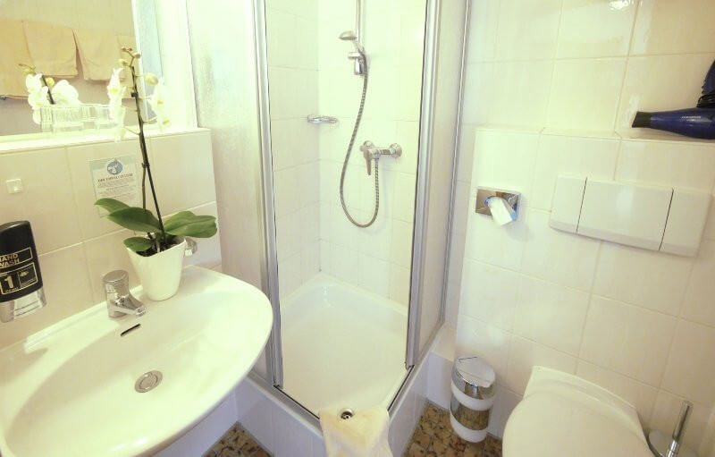 Blick ins Badezimmer mit Dusche, Waschbecken und WC