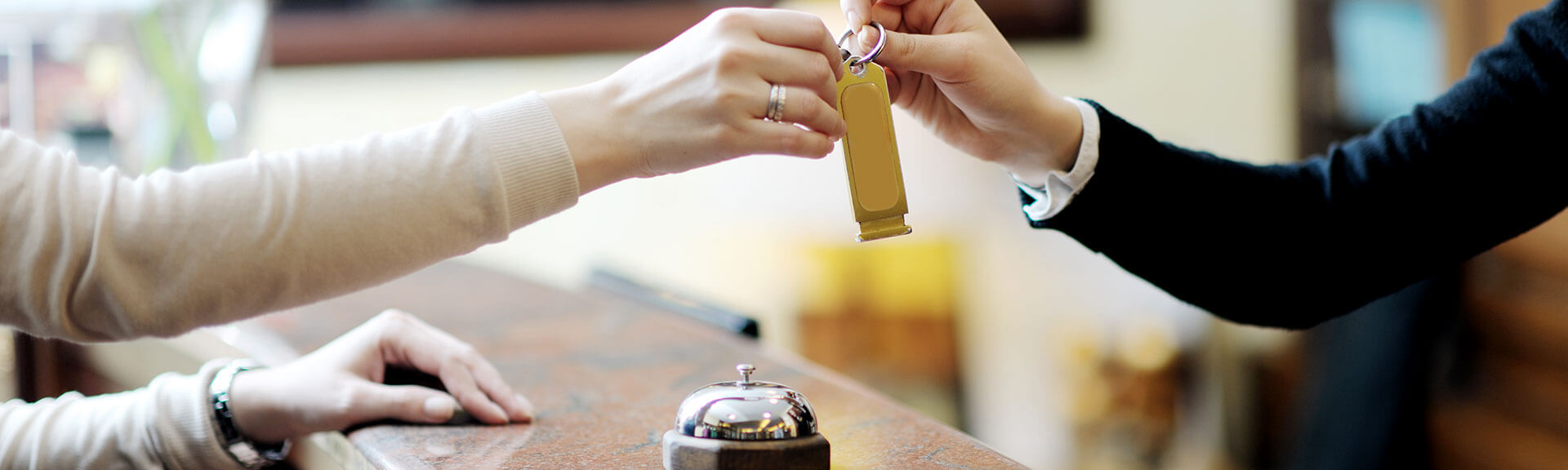 Hotel guest gets the room key for the hotel room at the reception desk