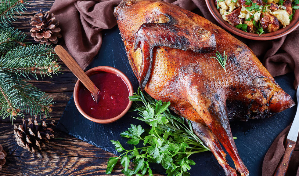 Weihnachtsbraten Truthahnbraten mit Cranberry-Sauce und Dressing aus Brot, Sellerie, Zwiebeln, Äpfeln, Kastanien und Kräutern.