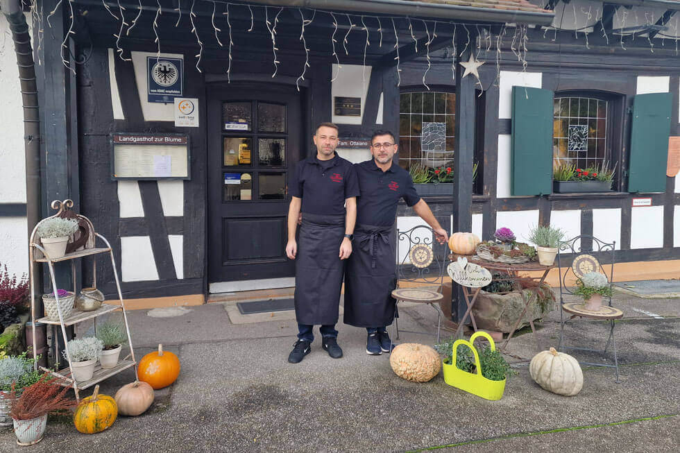 2 cooks in front of the restaurant