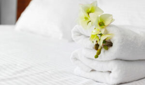 white towels on a hotel bed with a flower