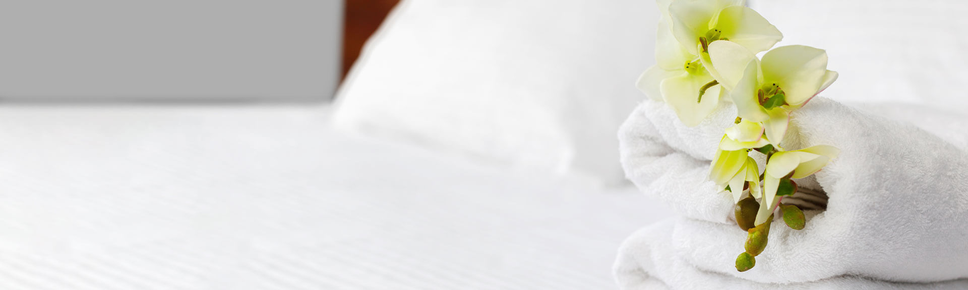 Hotelbett weiße Handtücher auf einem Hotelbett mit einer Blume