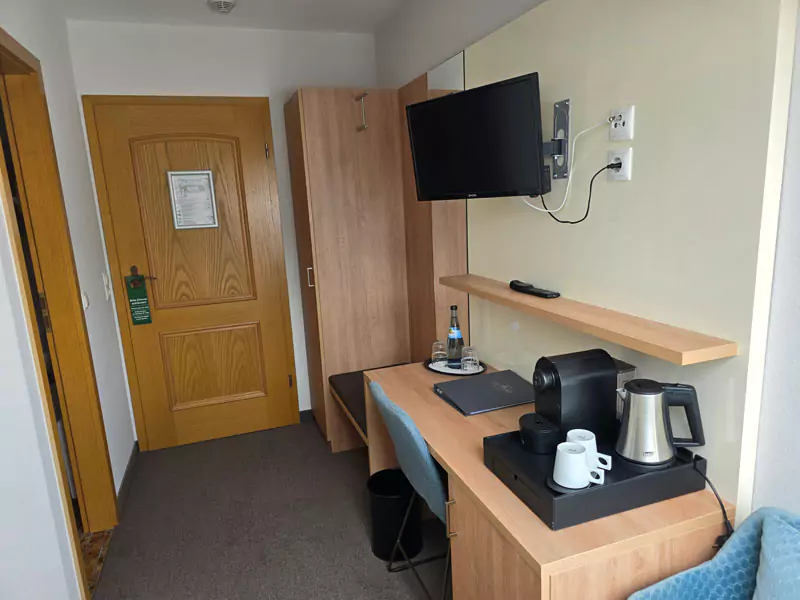 Schreibtisch mit Kaffeemaschine und Wasserkocher in einem Hotelzimmer